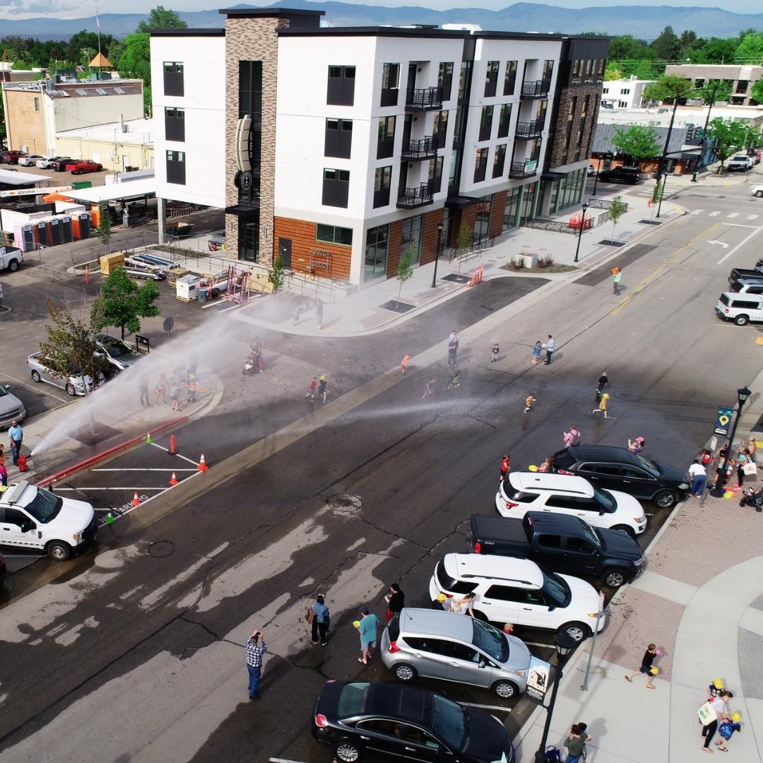 Drone shot overview of kids playing in the fire hydrant demo water